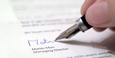 imagen de mano con pluma estilográfica firmando documento 